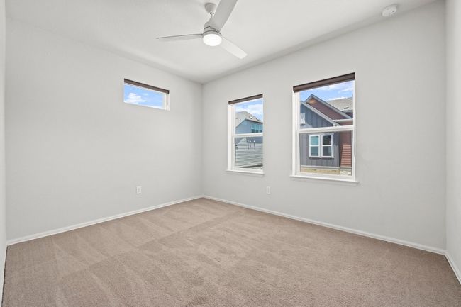 Carpeted spare room featuring a smoke detector and ceiling fan | Image 27