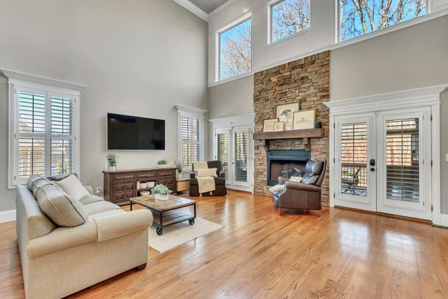 This grand living space boasts 20 ft ceilings and a stacked stone fireplace for chilly nights. | Image 8