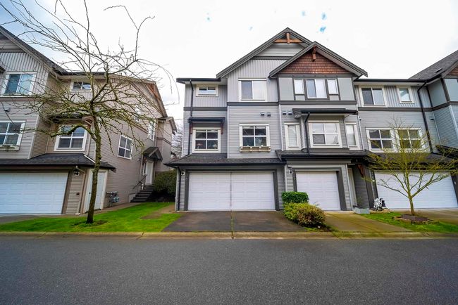 Townhome / multi-family property featuring driveway and a garage | Image 38