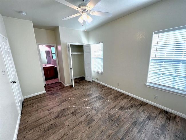 Unfurnished bedroom featuring wood finished floors, a closet, connected bathroom, and a ceiling fan | Image 8