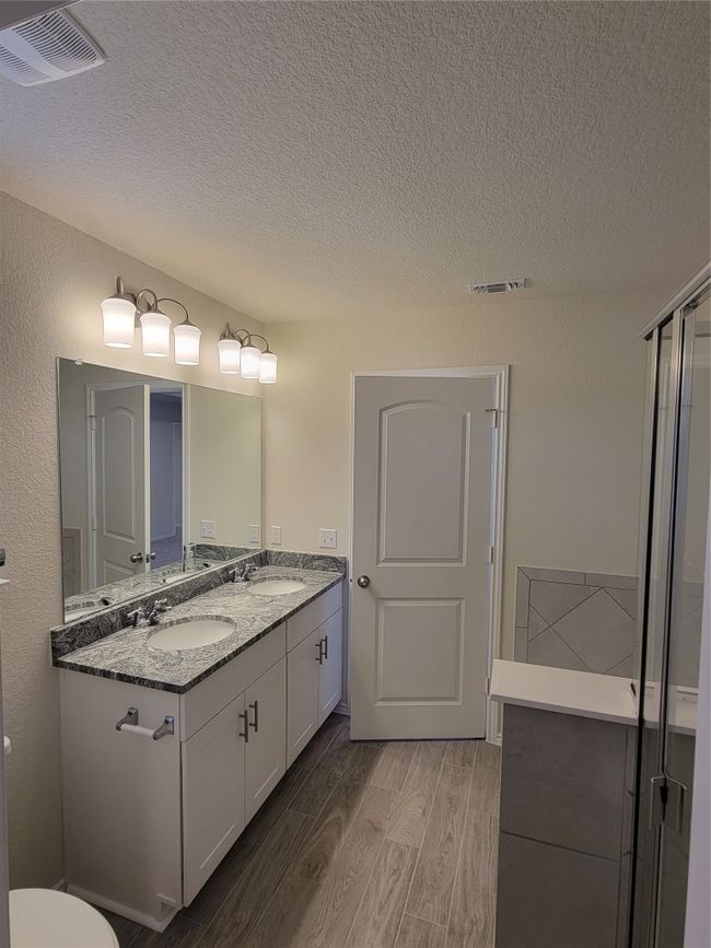 Full bath with a sink, visible vents, and wood finished floors | Image 21