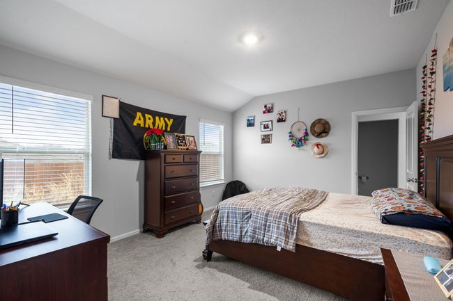 Bedroom featuring light carpet, baseboards, lofted ceiling, and visible vents | Image 16