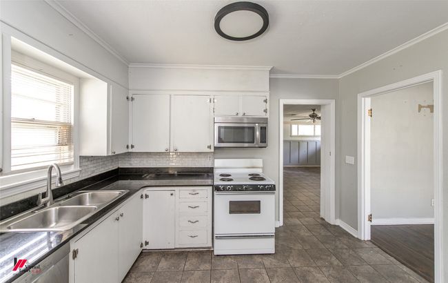 Kitchen with white cabinetry, a sink, stainless steel appliances, and a healthy amount of sunlight | Image 15