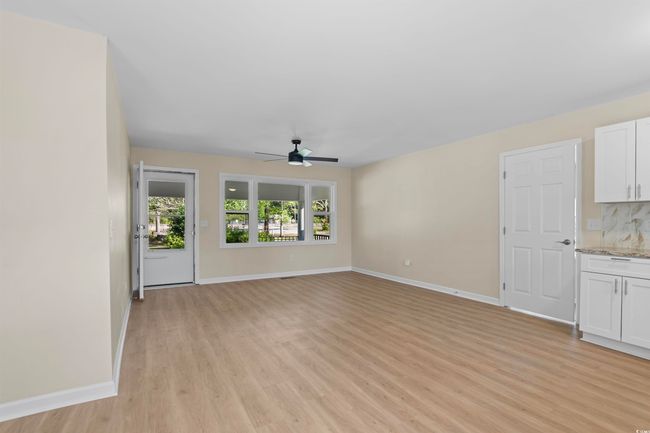 Unfurnished living room with a ceiling fan and light wood-style flooring | Image 18