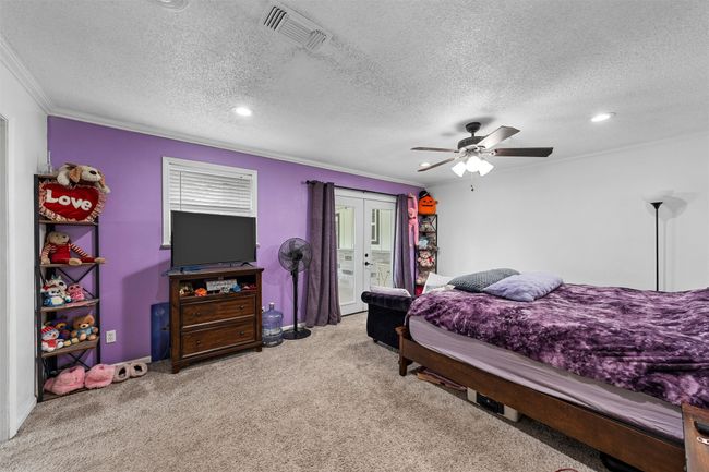 Carpeted bedroom featuring french doors, crown molding, a textured ceiling, ceiling fan, and recessed lighting | Image 18