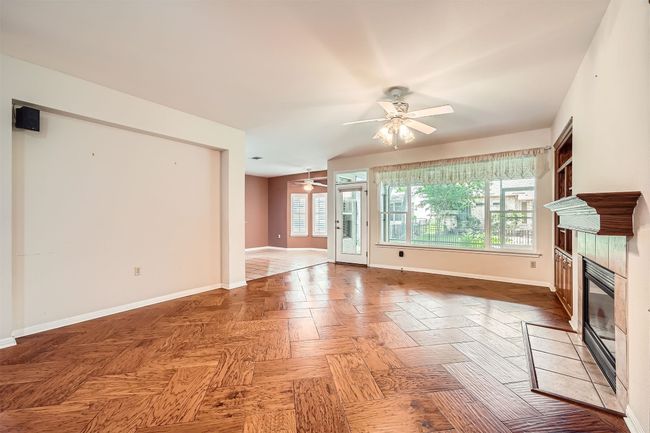 Unfurnished living room featuring a ceiling fan, a fireplace, and baseboards | Image 9
