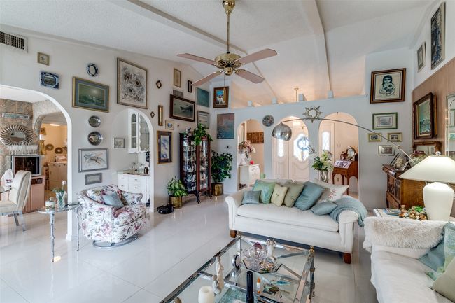Living room with arched walkways, ceiling fan, and tile patterned flooring | Image 8