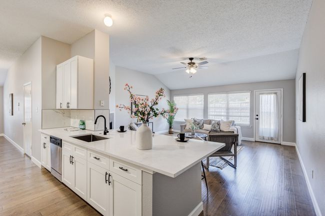 Kitchen featuring a sink, dishwasher, ceiling fan, a peninsula, and light wood-style floors | Image 11