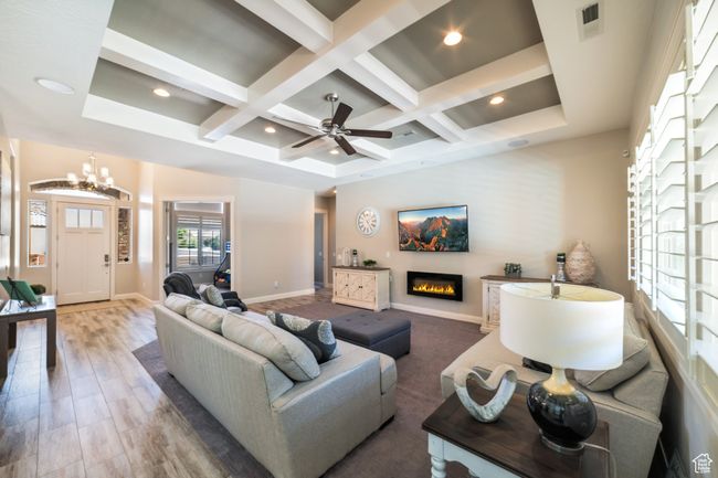 Living room with coffered ceiling, a glass covered fireplace, beam ceiling, and visible vents | Image 8