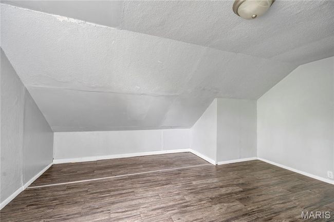Bonus room featuring a textured ceiling, wood finished floors, and lofted ceiling | Image 14