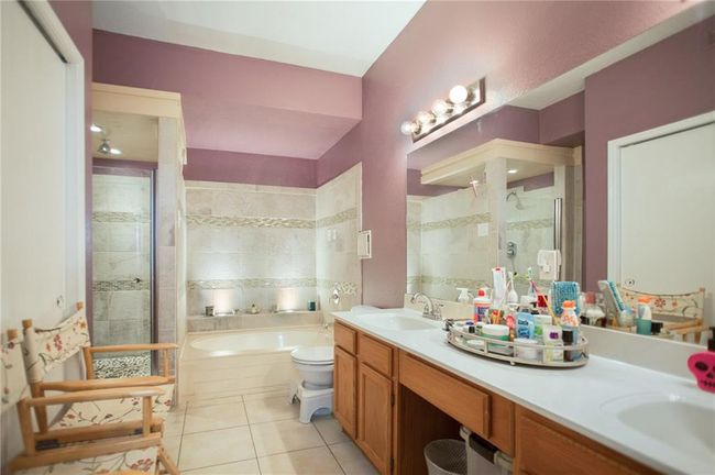 Bathroom with a stall shower, tile patterned floors, a garden tub, and double vanity | Image 16