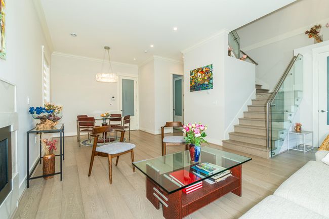 Living room with stairs, light wood-style flooring, crown molding, baseboards, and recessed lighting | Image 5