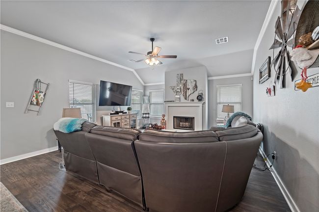 Living area featuring dark wood-style floors, crown molding, vaulted ceiling, and visible vents | Image 19