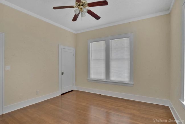 Unfurnished room with crown molding, wood finished floors, and a ceiling fan | Image 24