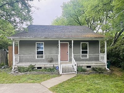 This updated cottage offers an inviting front porch and a private driveway for plentiful parking | Image 1