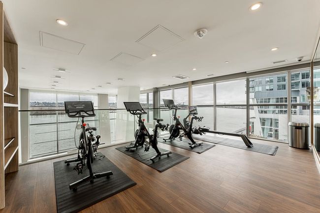 Workout area featuring a healthy amount of sunlight, expansive windows, and wood finished floors | Image 34