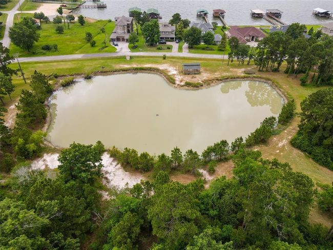One of the fishing ponds and green space in front of the home has a gazebo on the far side. Top left is one of two community boat ramps with restrooms and a nice sized fishing pier. This is a great spot to have morning walks! | Image 48