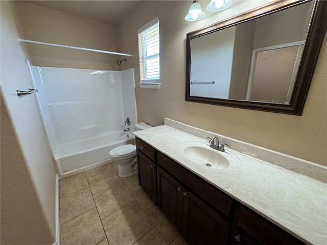 Full bath with vanity, tile patterned floors, toilet, and shower / bath combination | Image 13