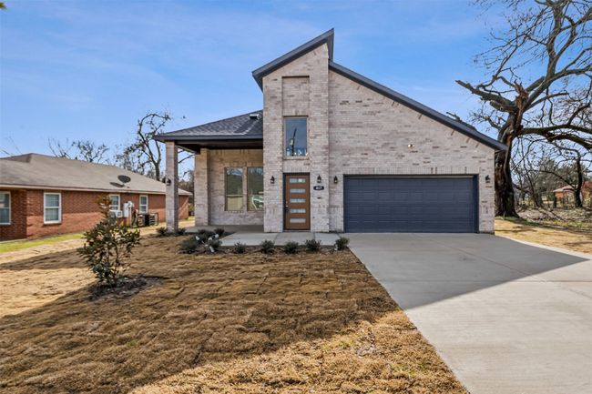 View of front of house featuring brick siding, driveway, a garage, and a shingled roof | Image 8
