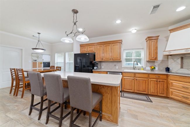Kitchen with huge island with breakfast bar. | Image 16