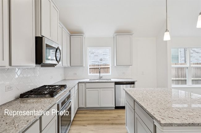 Kitchen with backsplash, plenty of natural light, stainless steel appliances, and a sink | Image 5