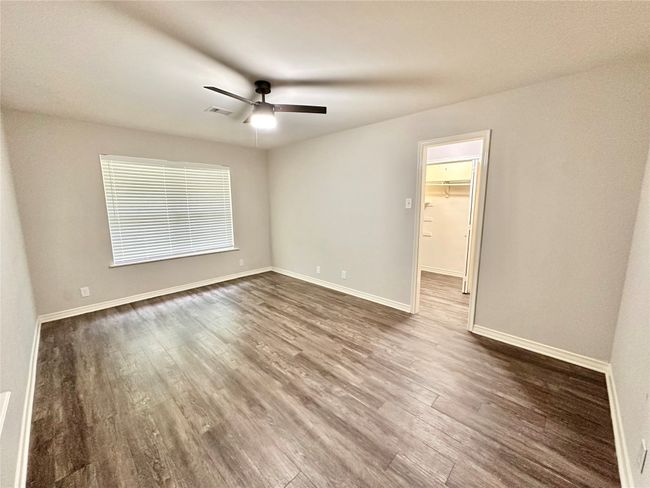 Empty room with dark wood-style flooring and ceiling fan | Image 18