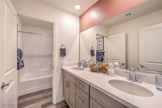 Photo is representational only; actual home finishes may vary. Full bathroom with wood finished floors, double vanity, and shower / washtub combination | Image 36