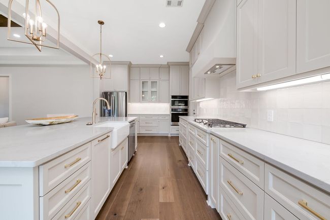 Kitchen featuring a chandelier, custom range hood, backsplash, dark wood finished floors, and recessed lighting | Image 17
