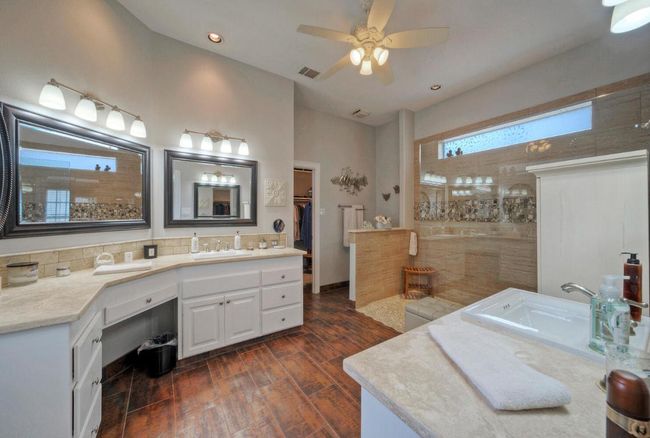 Full bath featuring vanity, a walk in shower, a ceiling fan, visible vents, and wood finished floors | Image 18