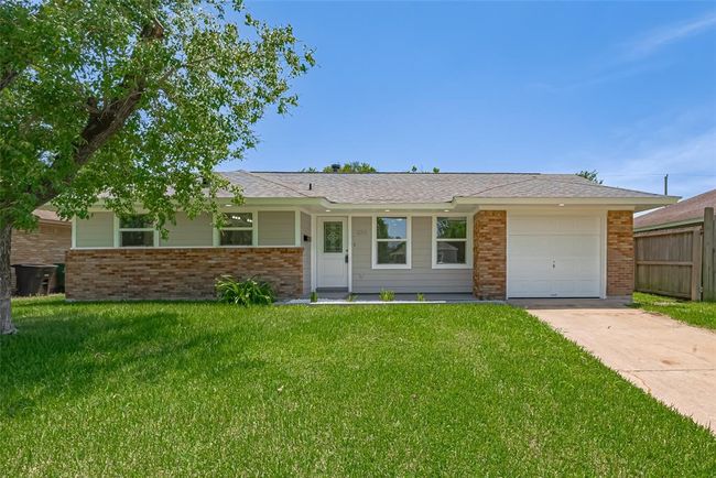 Fresh curb appeal is on full display with the neat front lawn, covered entryway, and a tasteful combination of brick and cement board siding. | Image 4