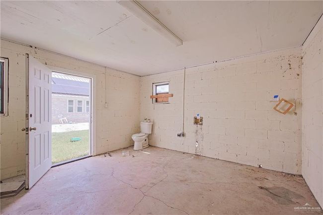 Empty room with concrete block wall and unfinished concrete floors | Image 27