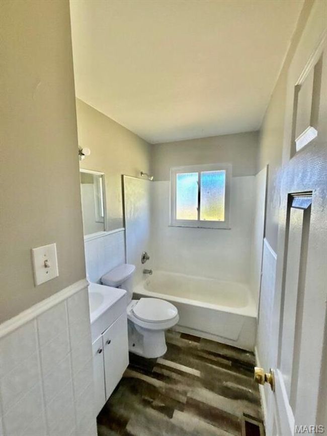 Bathroom featuring wood finished floors, toilet, shower combination, and vanity | Image 7