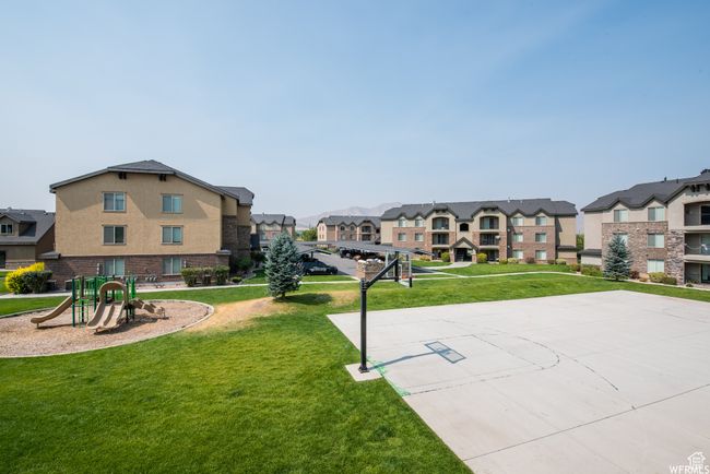 Surrounding community with community basketball court, a residential view, playground community, and a yard | Image 5
