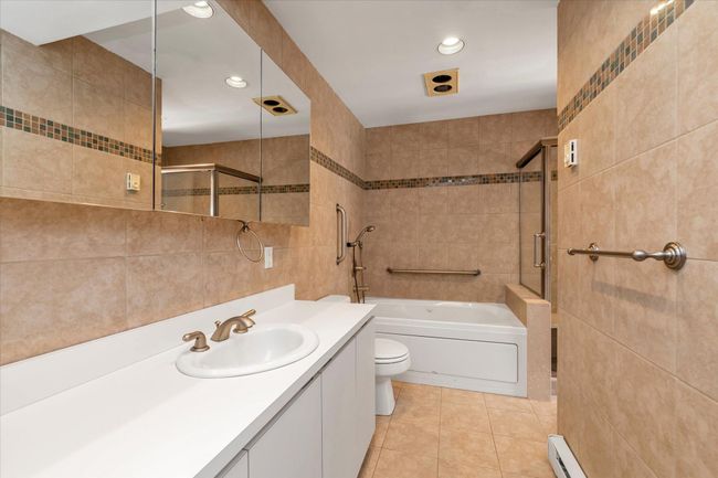 Full bath featuring a shower, toilet, a garden tub, tile patterned flooring, and tile walls | Image 17