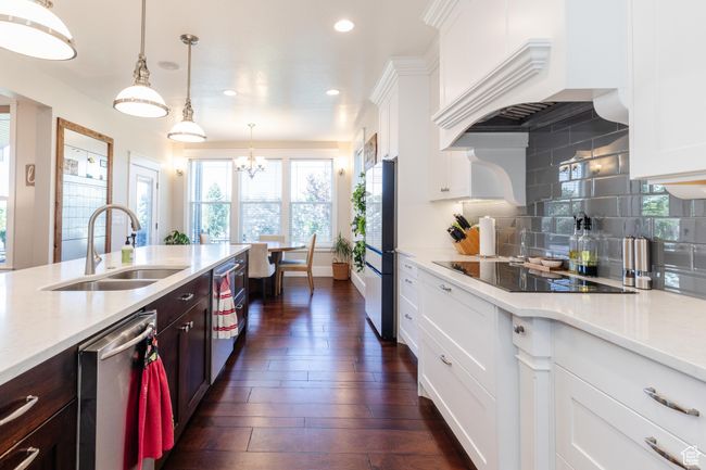 Kitchen with dishwasher, black electric stovetop, recessed lighting, white cabinetry, and backsplash | Image 11