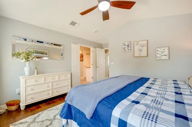 Bedroom with lofted ceiling, wood finished floors, and a ceiling fan | Image 23