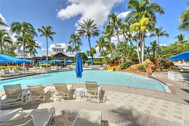 Pool with a water slide and a patio area | Image 39