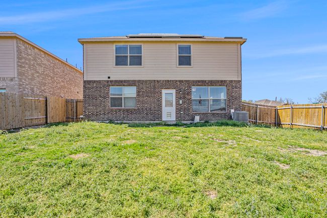 Back of house featuring a fenced backyard, brick, siding, and a lawn | Image 25