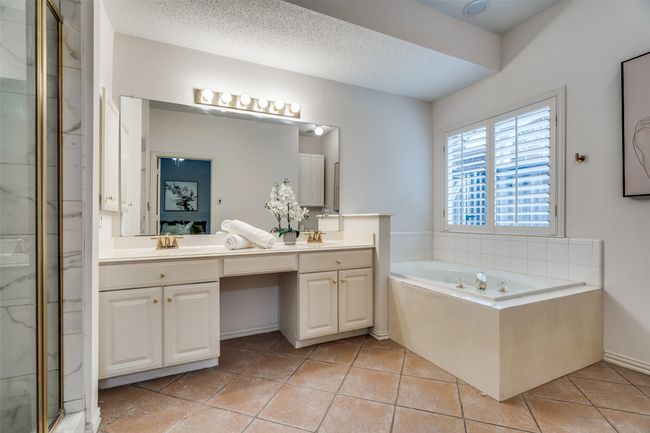 Bathroom with double vanity, a shower stall, a garden tub, tile patterned flooring, and a textured ceiling | Image 16