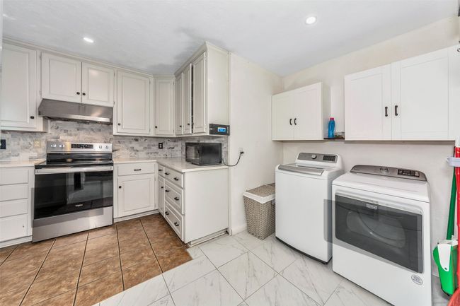 Washroom featuring washing machine and clothes dryer and recessed lighting | Image 30