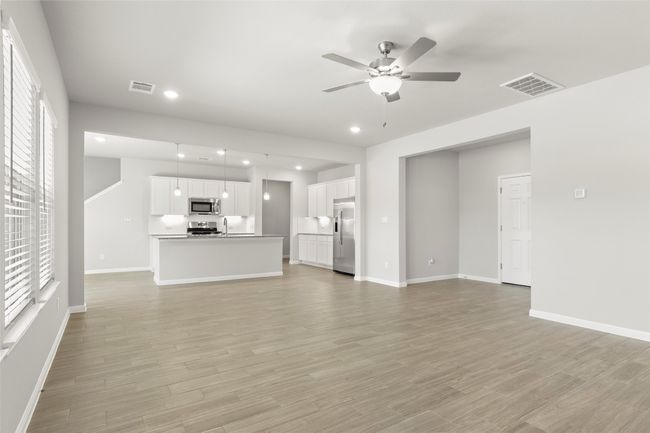 Unfurnished living room with ceiling fan, healthy amount of natural light, baseboards, light wood-type flooring, and recessed lighting | Image 8