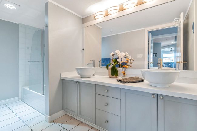 Full bath featuring tile patterned flooring, double vanity, crown molding, and a sink | Image 20