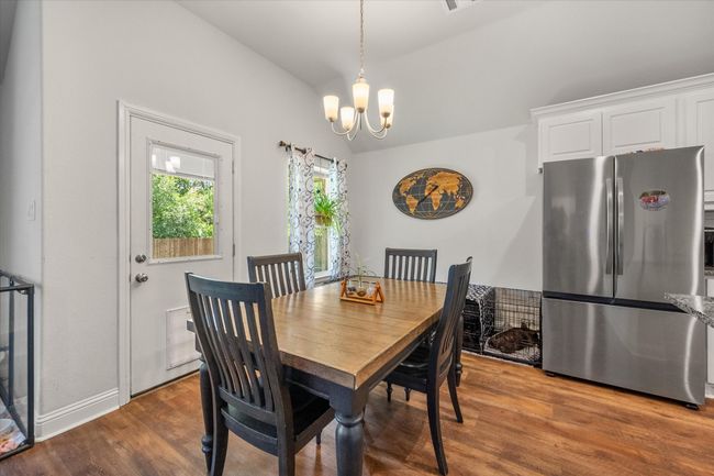 Dining room with a chandelier, vaulted ceiling, and wood finished floors | Image 11