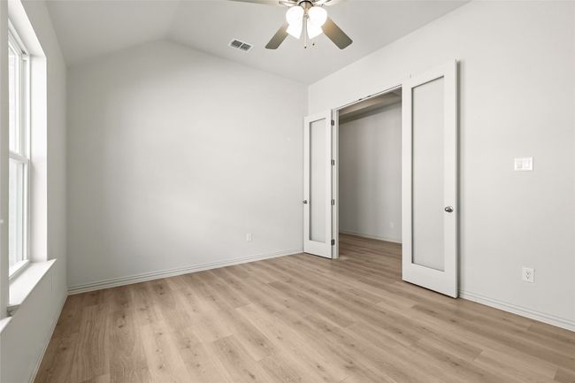 Unfurnished bedroom featuring light wood-style flooring, vaulted ceiling, and ceiling fan | Image 14