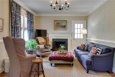 Living room with crown molding, a fireplace, hardwood / hardwood flooring, and a chandelier | Image 3