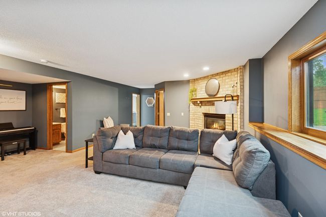 Lower level family room featuring a cozy gas fireplace—perfect for relaxing evenings | Image 31