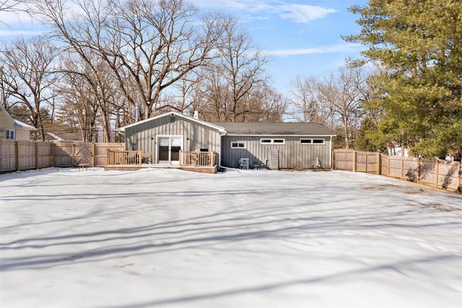 Snow covered house featuring board and batten siding and a fenced backyard | Image 40