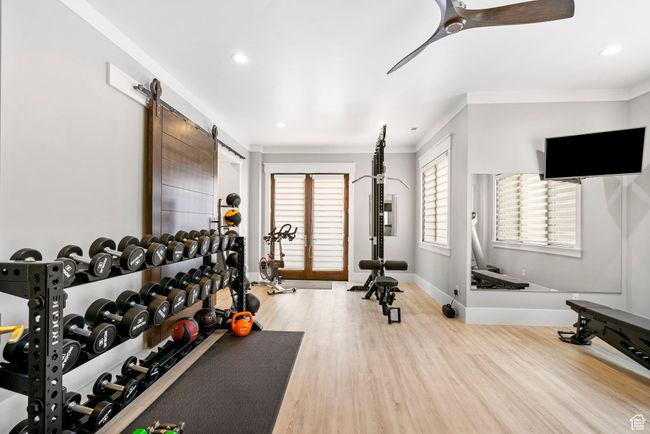 Exercise area featuring wood finished floors, baseboards, a ceiling fan, and recessed lighting | Image 80