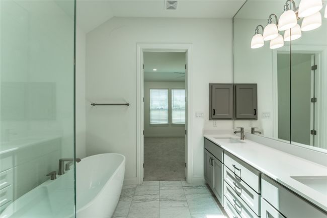 Bathroom with marble finish flooring, double vanity, and a freestanding tub | Image 27