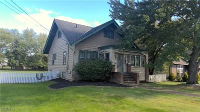 View of property exterior featuring a yard and a sunroom | Image 1